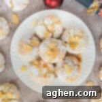 Soft Amaretti Cookies piled on a white plate surrounded by more cookies