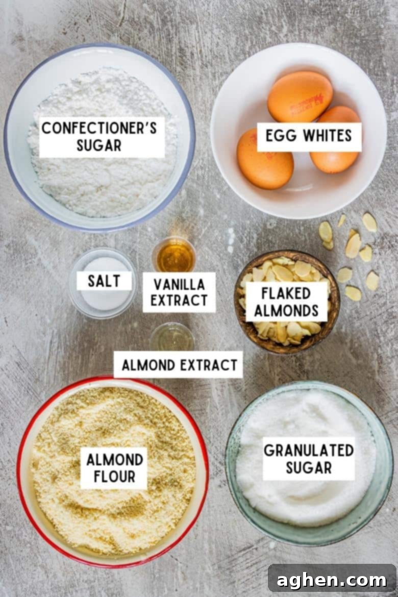 Ingredients on countertop: almond flour, granulated sugar, salt, confectioners sugar, 3 medium size eggs, vanilla extract, almond extract, flaked almonds 