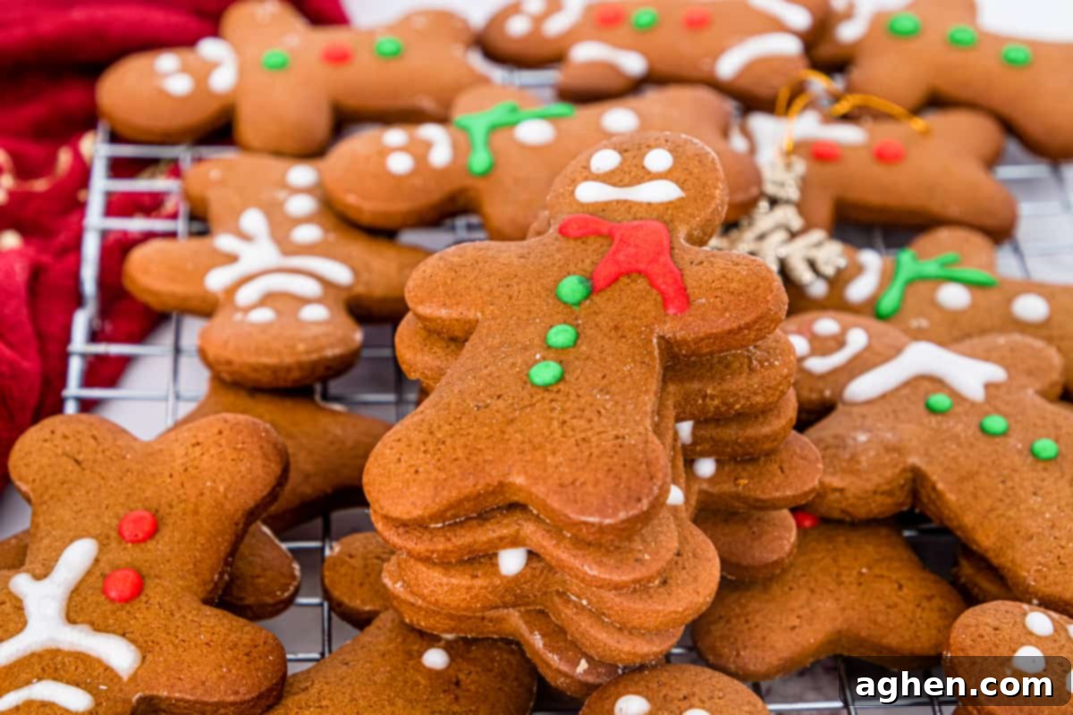 Christmas gingerbread men cookies decorated with eyes, buttons, and scarf using red, green, and white icing