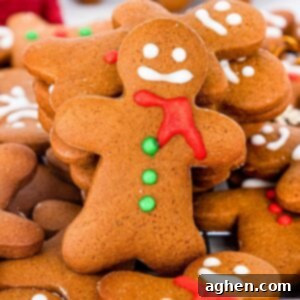 homemade gingerbread men cookies decorated with eyes, mouth, scarf, and buttons using icing