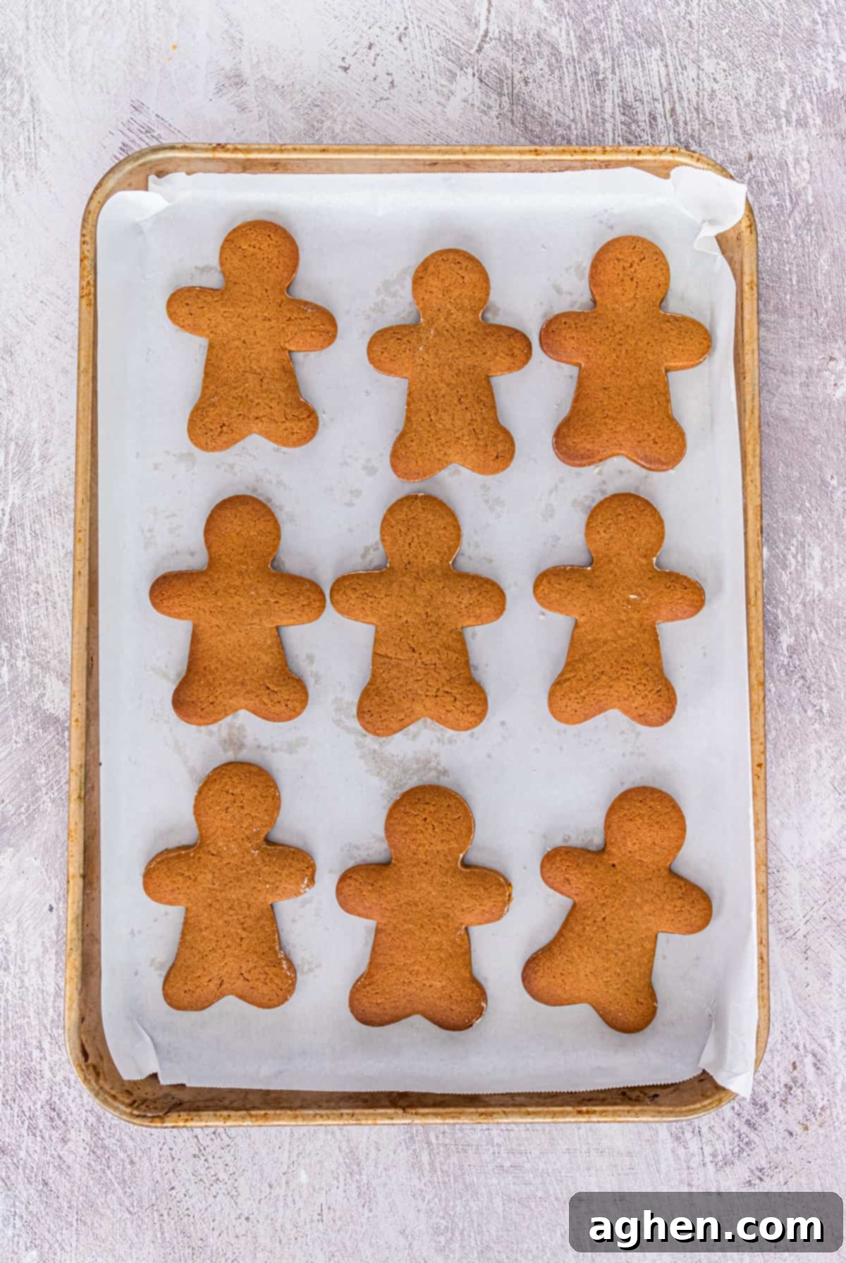 undecorated gingerbread men cookies on parchment-lined baking sheet