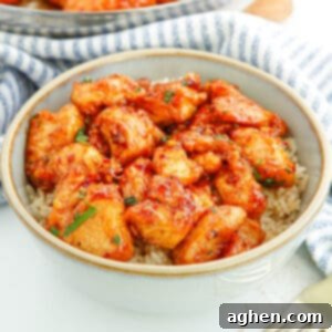 Sweet and spicy honey garlic chicken bites served over rice in a bowl.