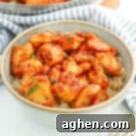 Sweet and spicy honey garlic chicken bites served over rice in a bowl.
