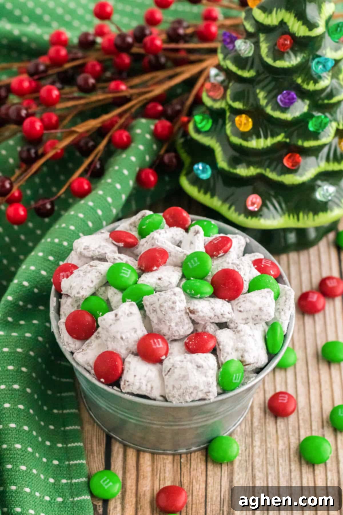 small bowl of reindeer chow with holiday M&Ms on a table with christmas decorations