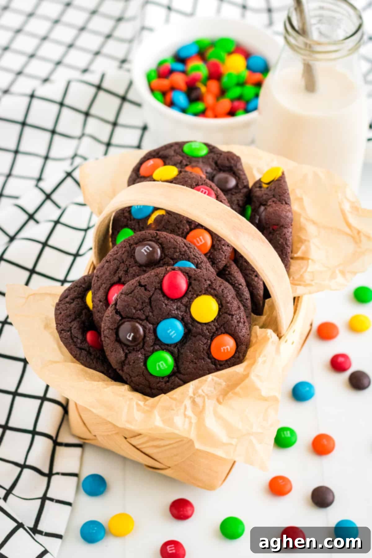 Easy M&M Chocolate Cake Mix Cookies 3 Chocolate M&M cookies in parchment lined basket, ready to be served or stored.