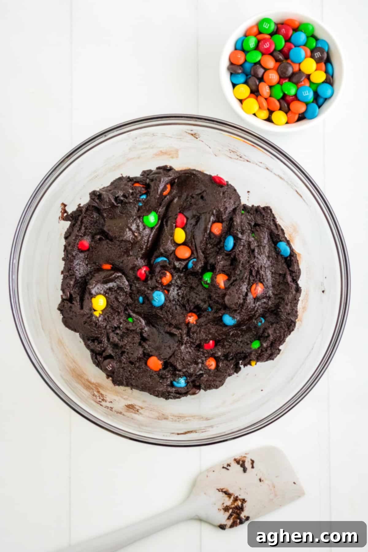 Easy M&M Chocolate Cake Mix Cookies 5 Chocolate M&M Cookie Batter in mixing bowl with spatula and M&Ms next to it, ready for chilling.