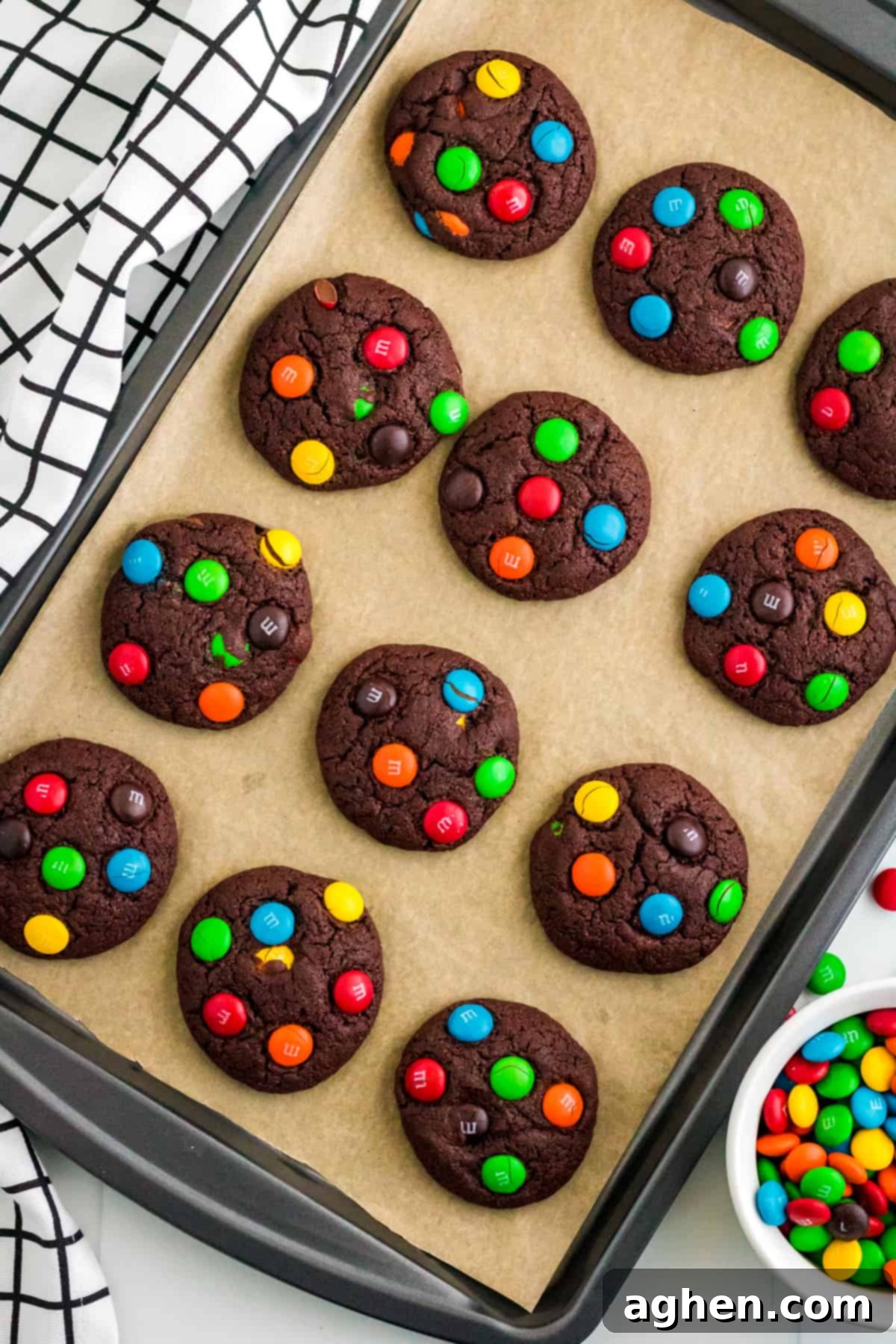 Easy M&M Chocolate Cake Mix Cookies 7 Chocolate M&M Cookies fresh out of the oven on a parchment lined baking sheet.