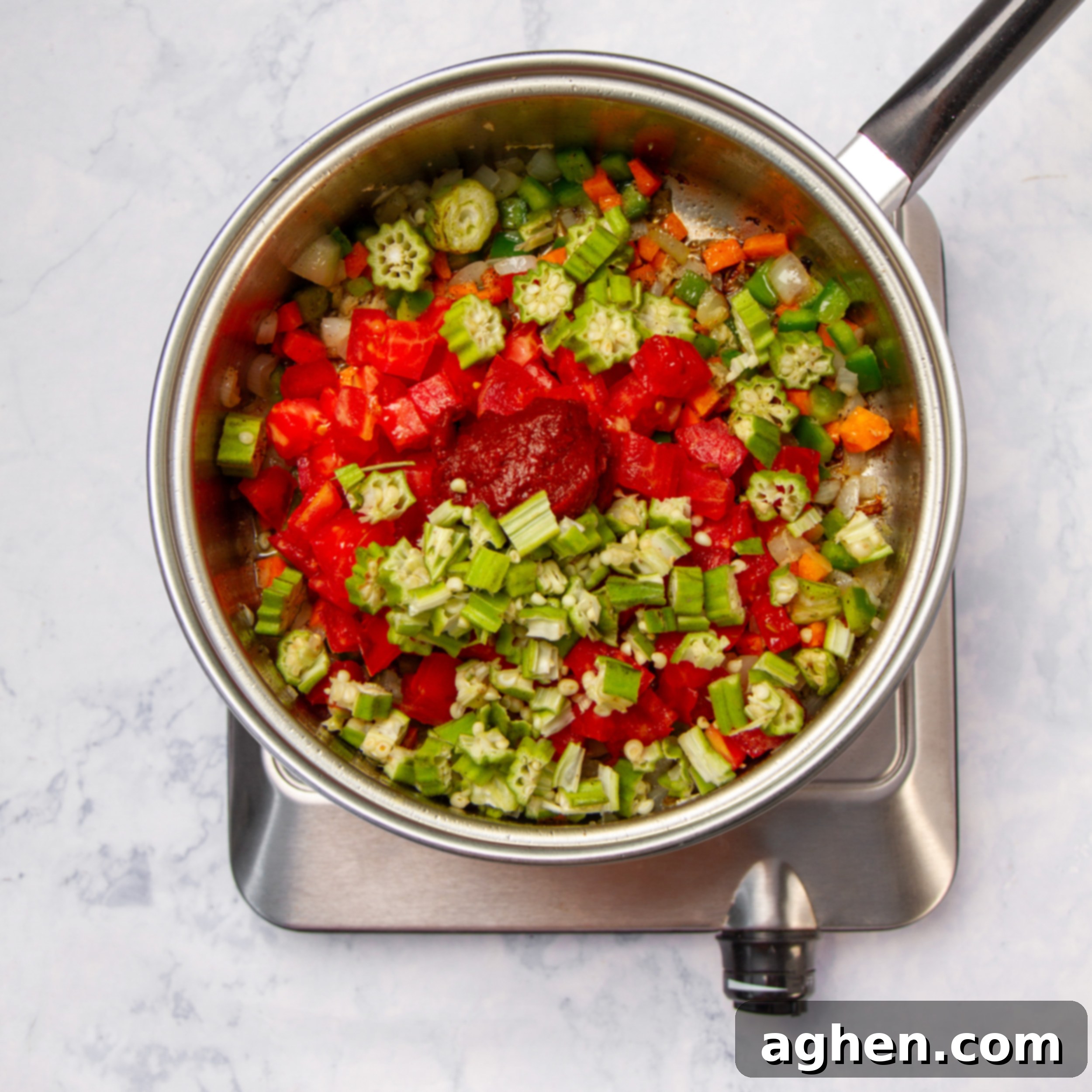 Authentic Okra Goodness 5 Colorful sautéed carrots, bell peppers, onions, garlic, and ginger in a pot.