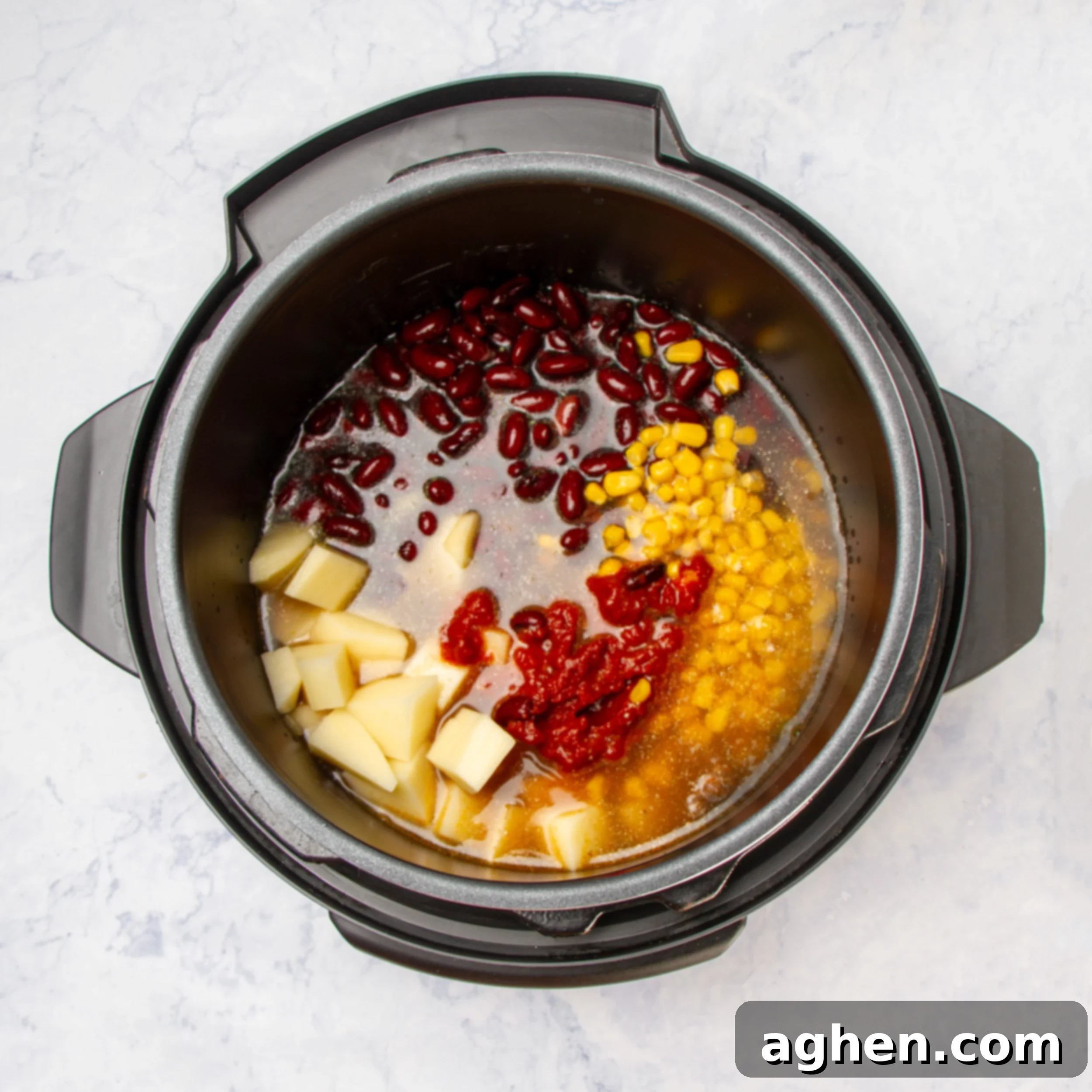 Beef broth being poured into the Instant Pot with all other Cowboy Soup ingredients, ready for pressure cooking.