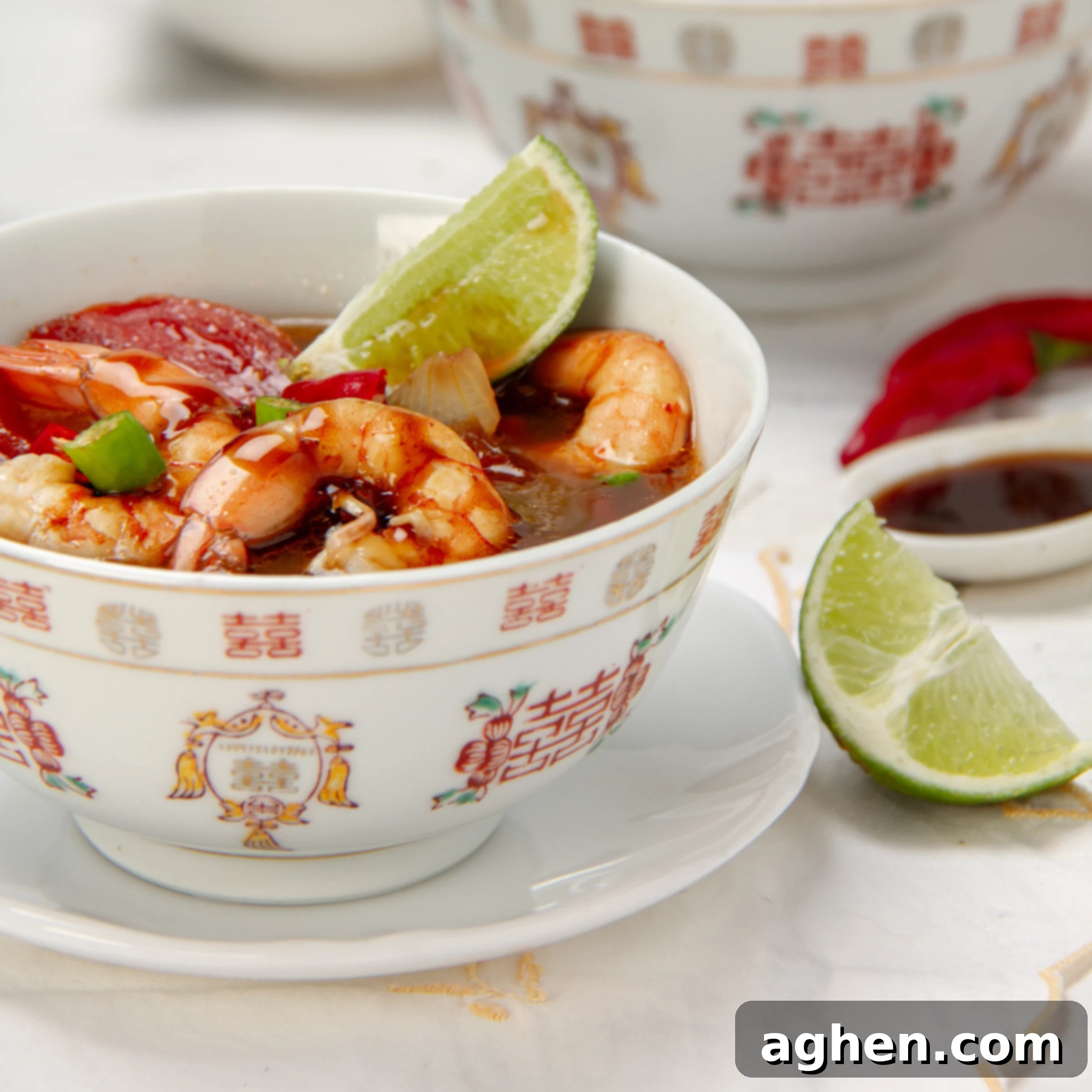 Tom Yum Soup 2 Thai classic Tom Yum Soup with shrimp in a bowl, garnished with a fresh lime wedge.