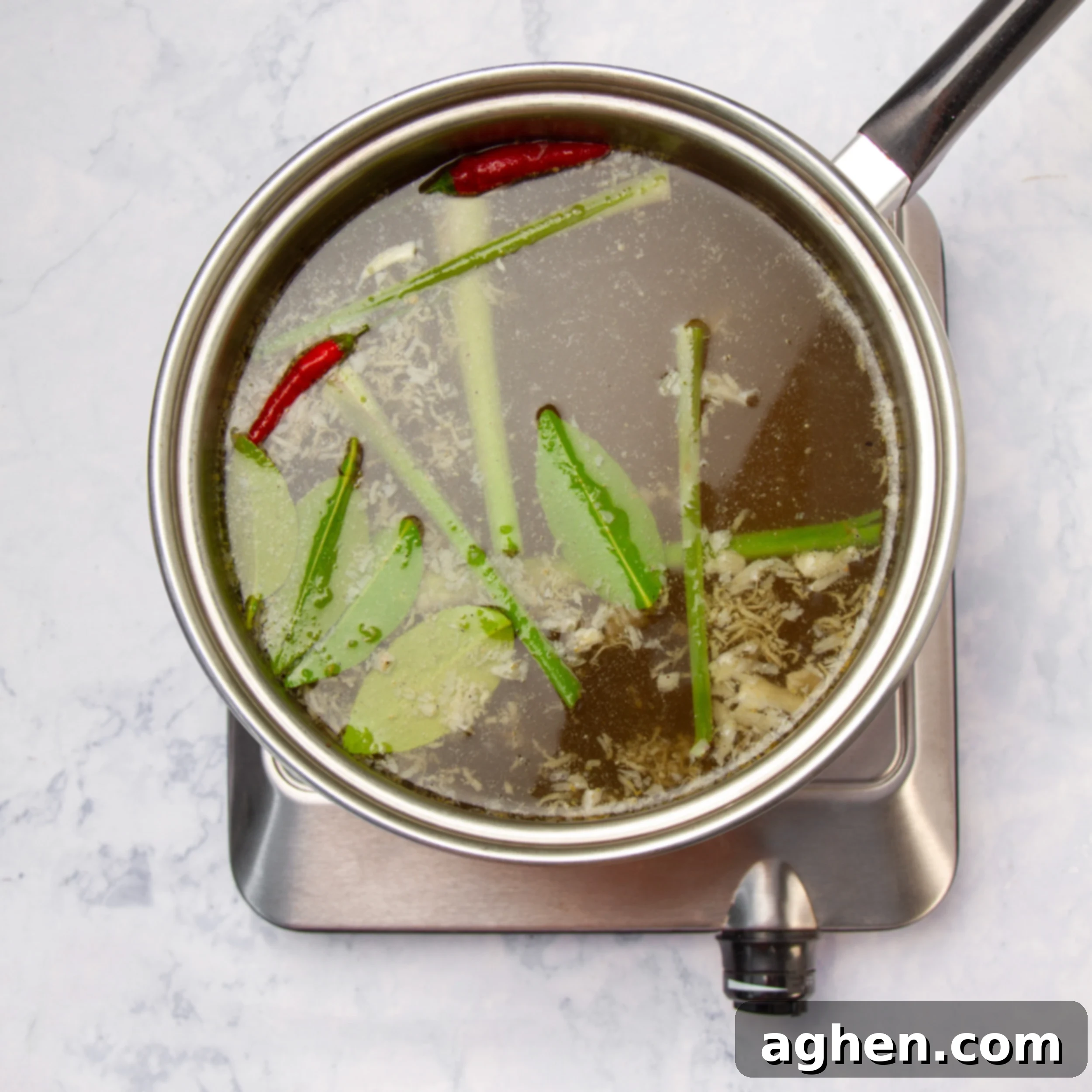 Tom Yum Soup 5 Tom yum soup broth slowly cooking in a large pot, releasing its aromatic steam.