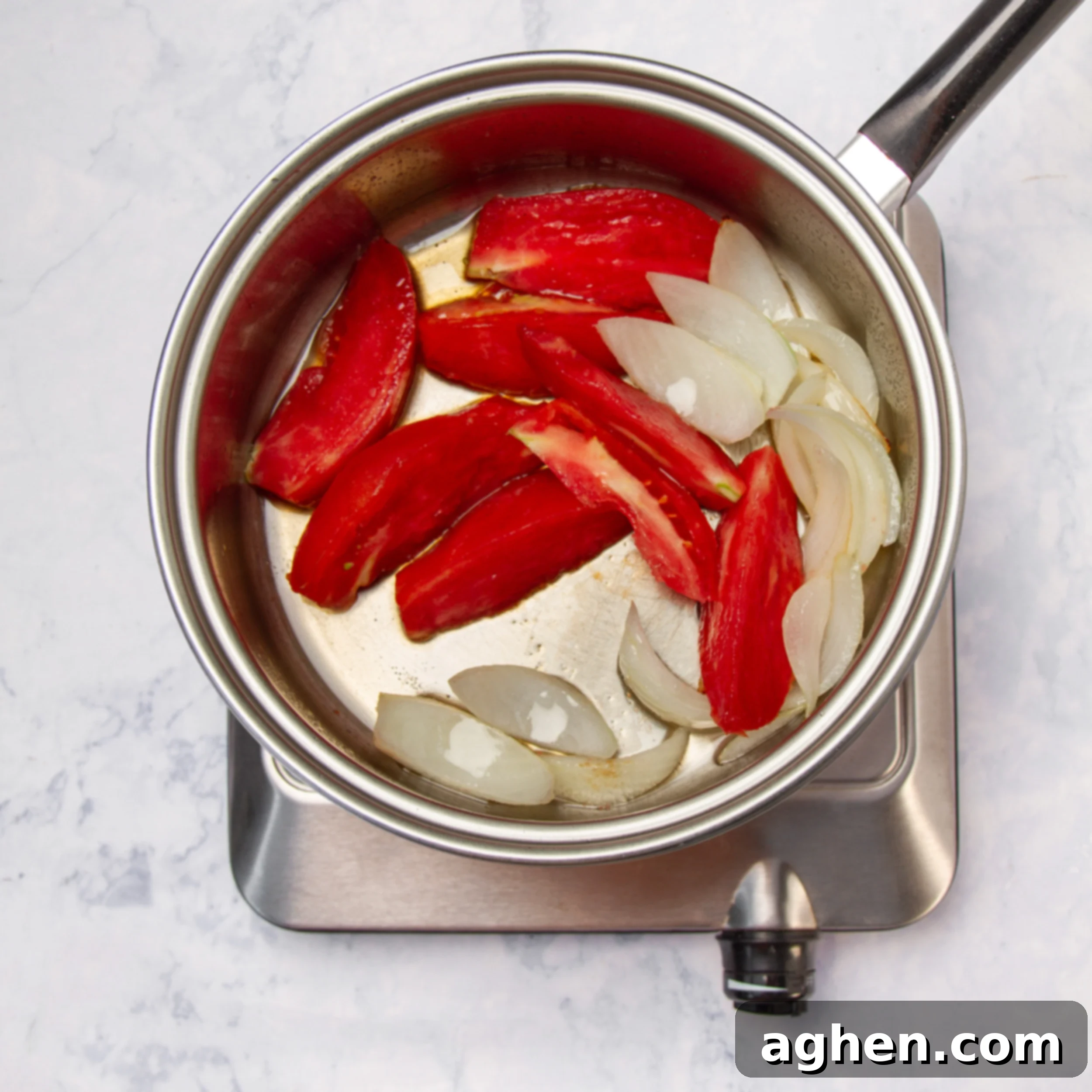 Tom Yum Soup 6 Onions and tomatoes gently sautéing in a pot for Tom Yum soup, becoming slightly tender.