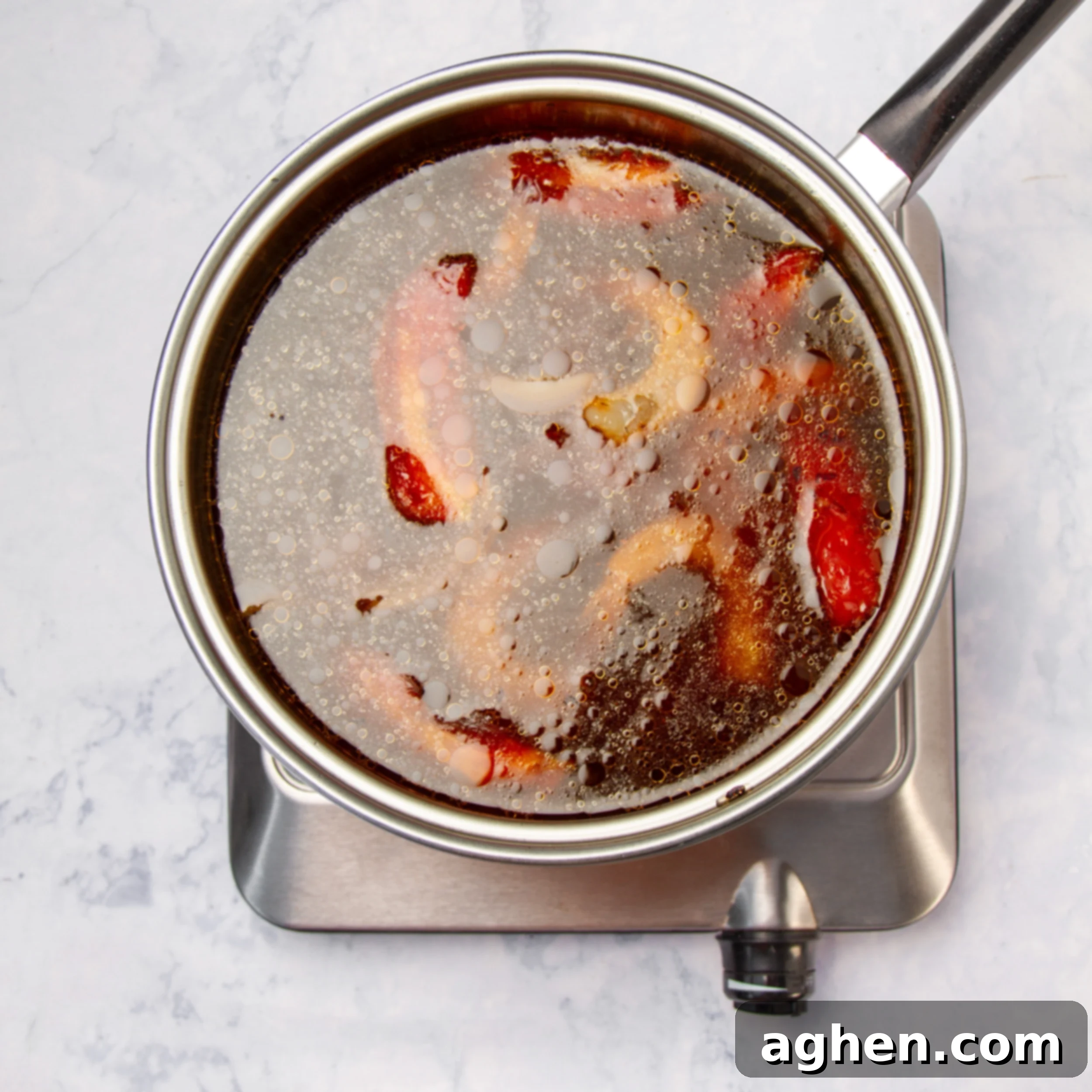 Tom Yum Soup 8 Fresh shrimp added to the pot of cooking Tom Yum Soup, turning pink as they cook.
