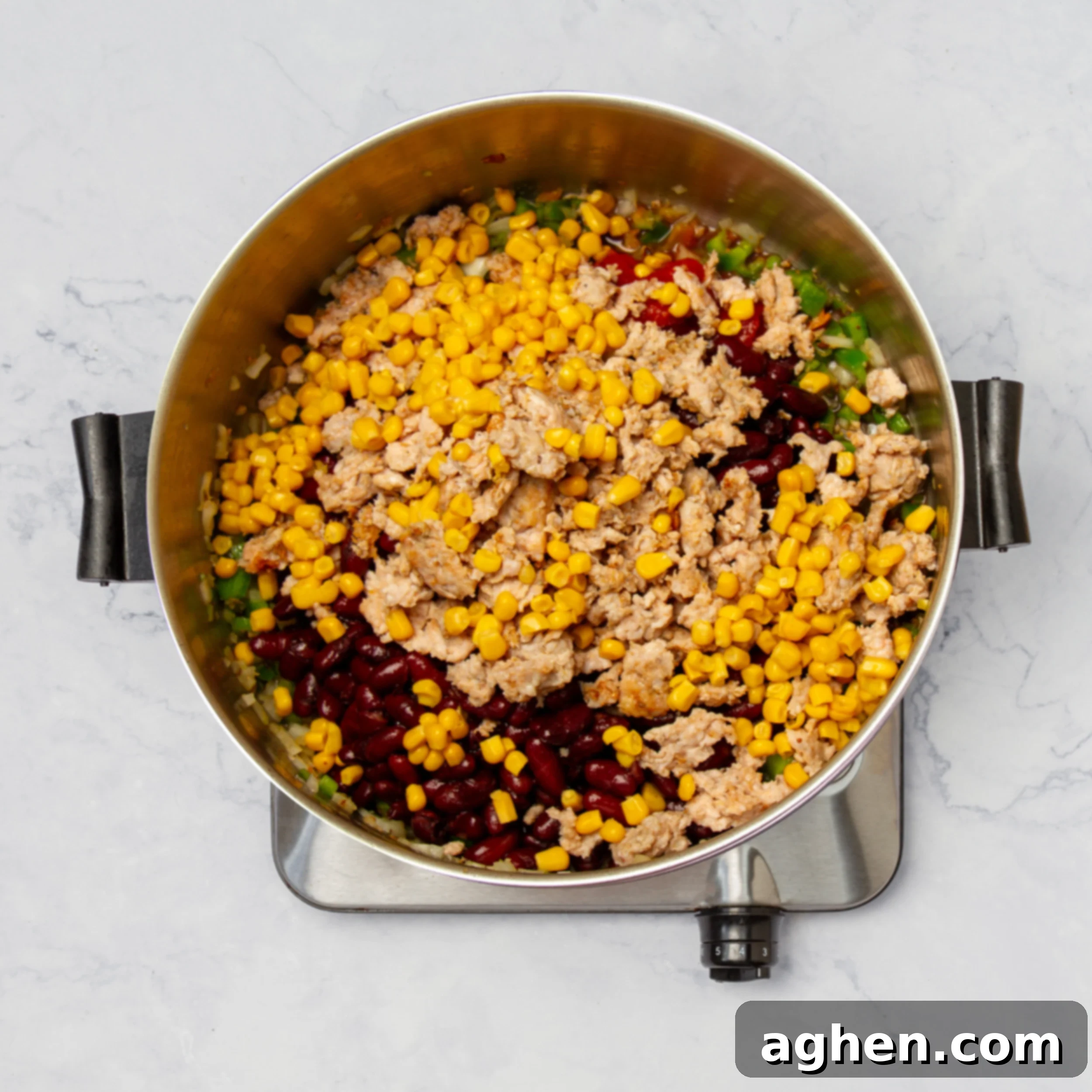 Weight Watchers Turkey Taco Soup: A Fall Favorite 6 Kidney beans added to the pot with vegetables and tomatoes, being stirred.