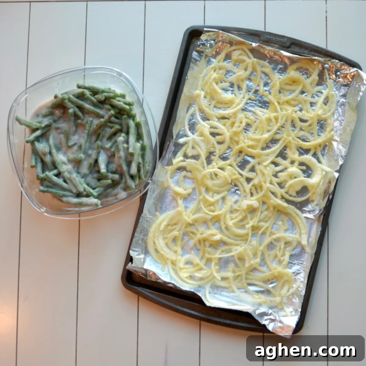 A close-up of fresh green beans and thinly sliced yellow onions, prepared and ready for the next steps of the casserole recipe.