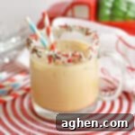 Gingerbread cocktail with vodka and kahlua in glass mug with sprinkles on rim and two paper straws. Christmas decor is in the background.