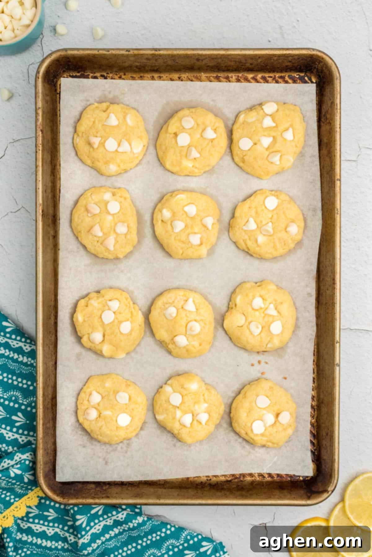 Freshly baked lemon pudding cookies with white chocolate chips, still warm on the cookie sheet.
