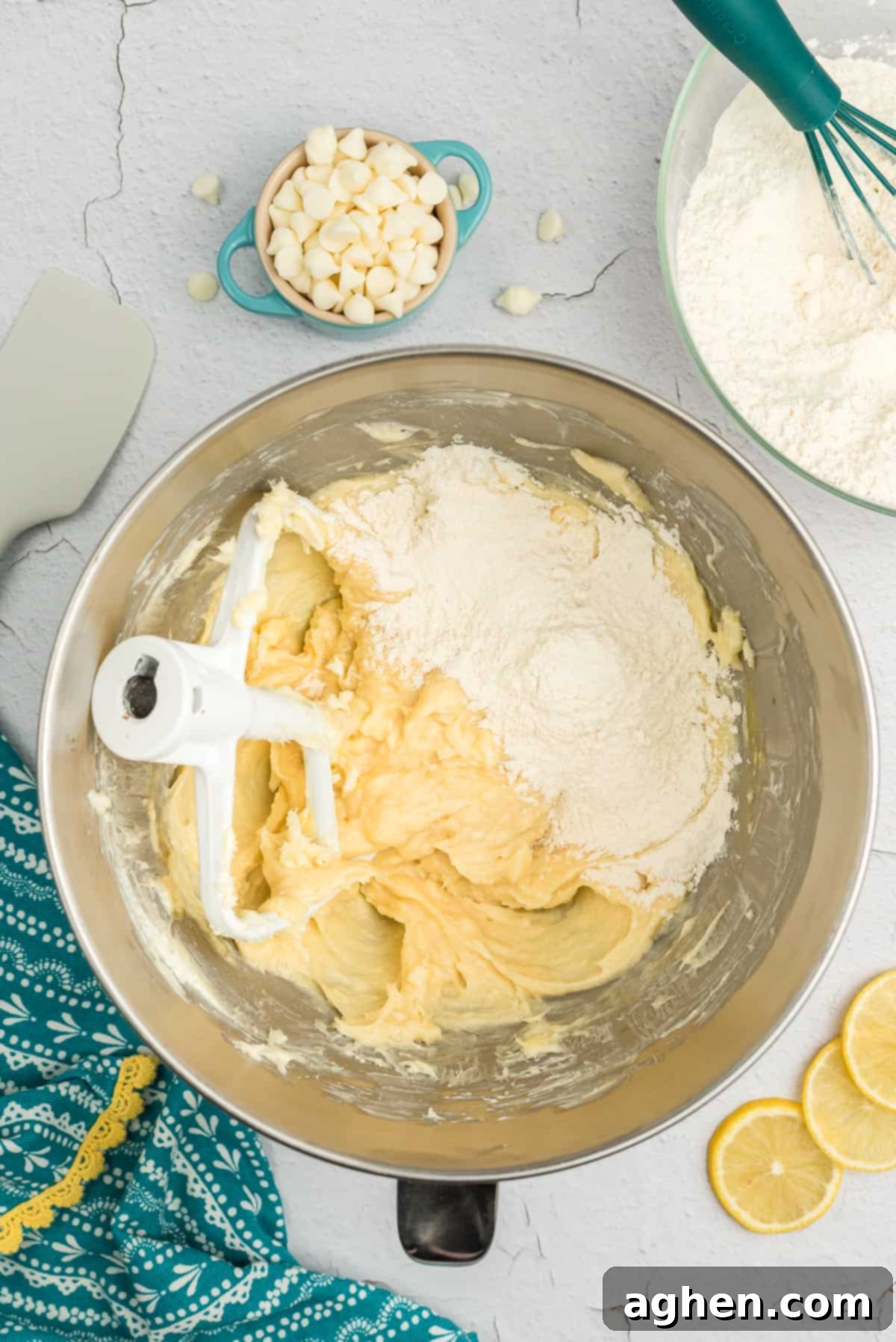 Dry ingredients being incorporated into the wet mixture in the bowl of a stand mixer to form lemon cookie dough.