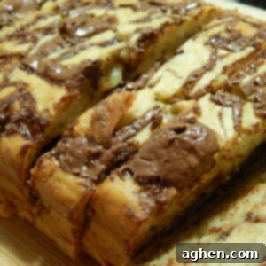 Close-up of baked Banana Nutella Loaf, showcasing a golden crust and chocolate swirls