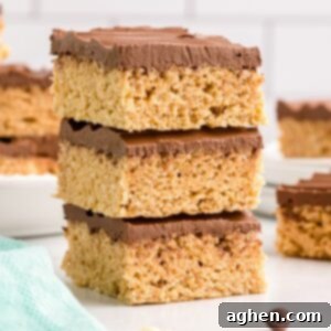 Peanut butter rice krispie treats with chocolate topping stacked on top of each other on white plate.