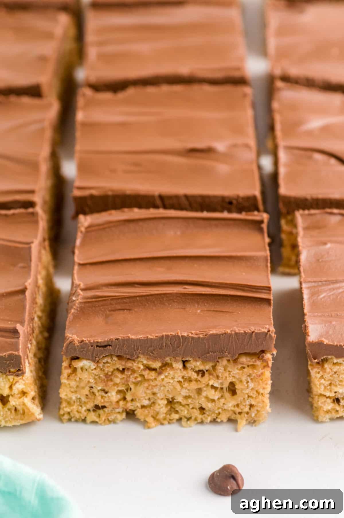 Peanut butter rice krispie treats with chocolate topping sliced and lined up neatly.