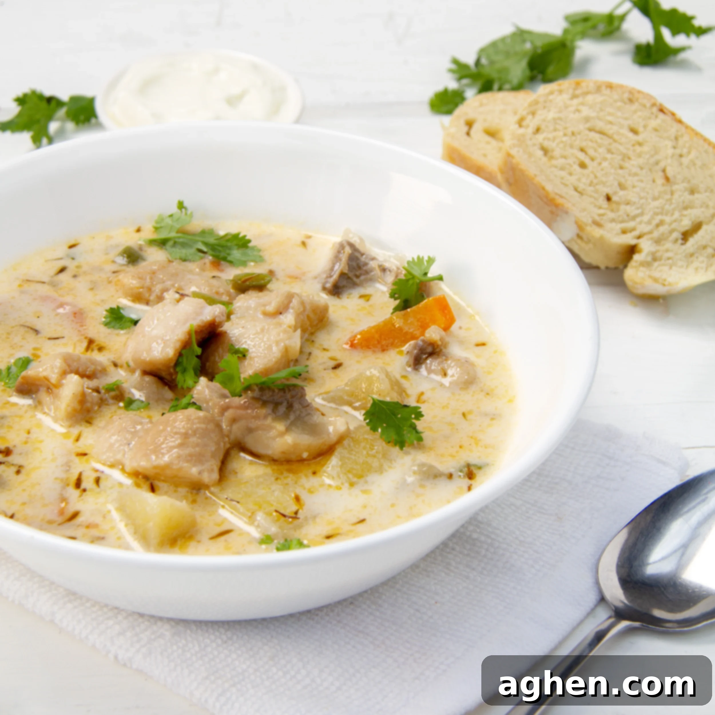 Restaurant-Quality Cod Chowder, Surprisingly Simple 2 Creamy cod chowder in a bowl with bread and a spoon on the side.