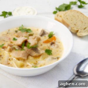 Restaurant-Quality Cod Chowder, Surprisingly Simple 7 Creamy cod chowder in a bowl with bread and a spoon on the side.