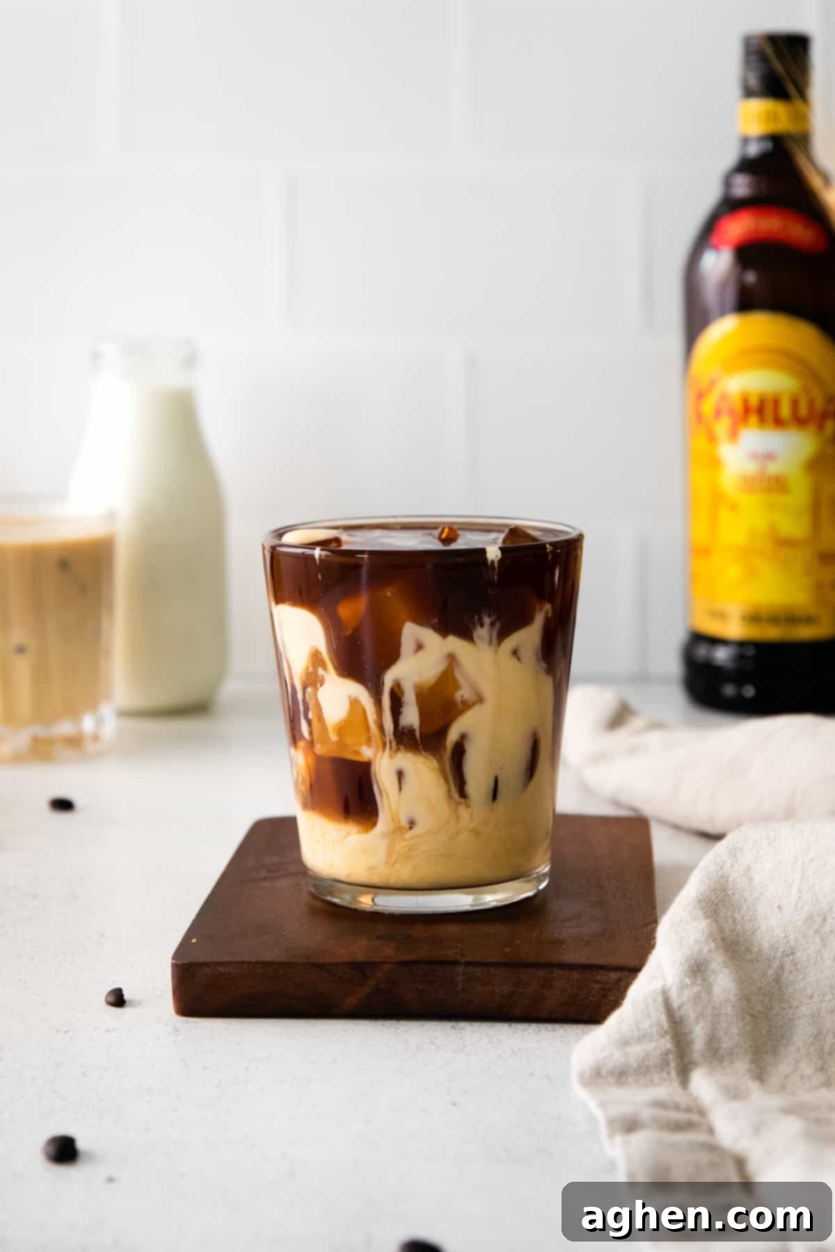 Beautifully layered Eggnog White Russian cocktail before stirring, showcasing the distinct layers of coffee liqueur and creamy eggnog.