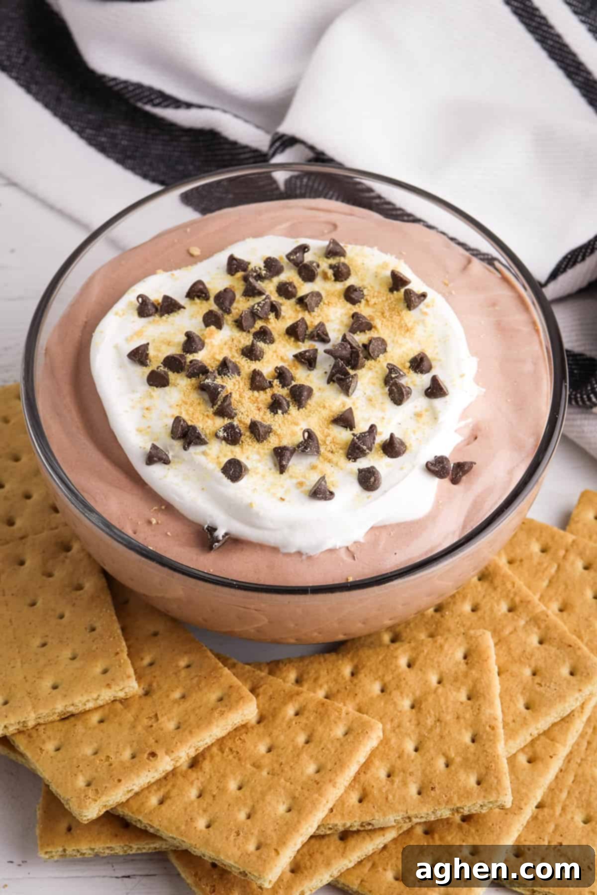 Decadent Chocolate Pie Dip 5 Ready-to-serve Chocolate Pudding Dip with layers of chocolate pudding and whipped topping, garnished with mini chocolate chips and graham cracker crumbs, surrounded by graham crackers for dipping.