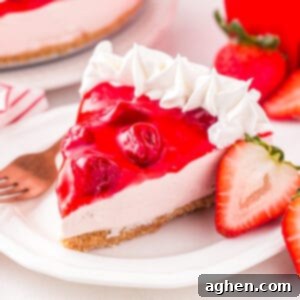 Slice of no bake strawberry cheesecake with strawberry topping and whipped cream piping on edge.