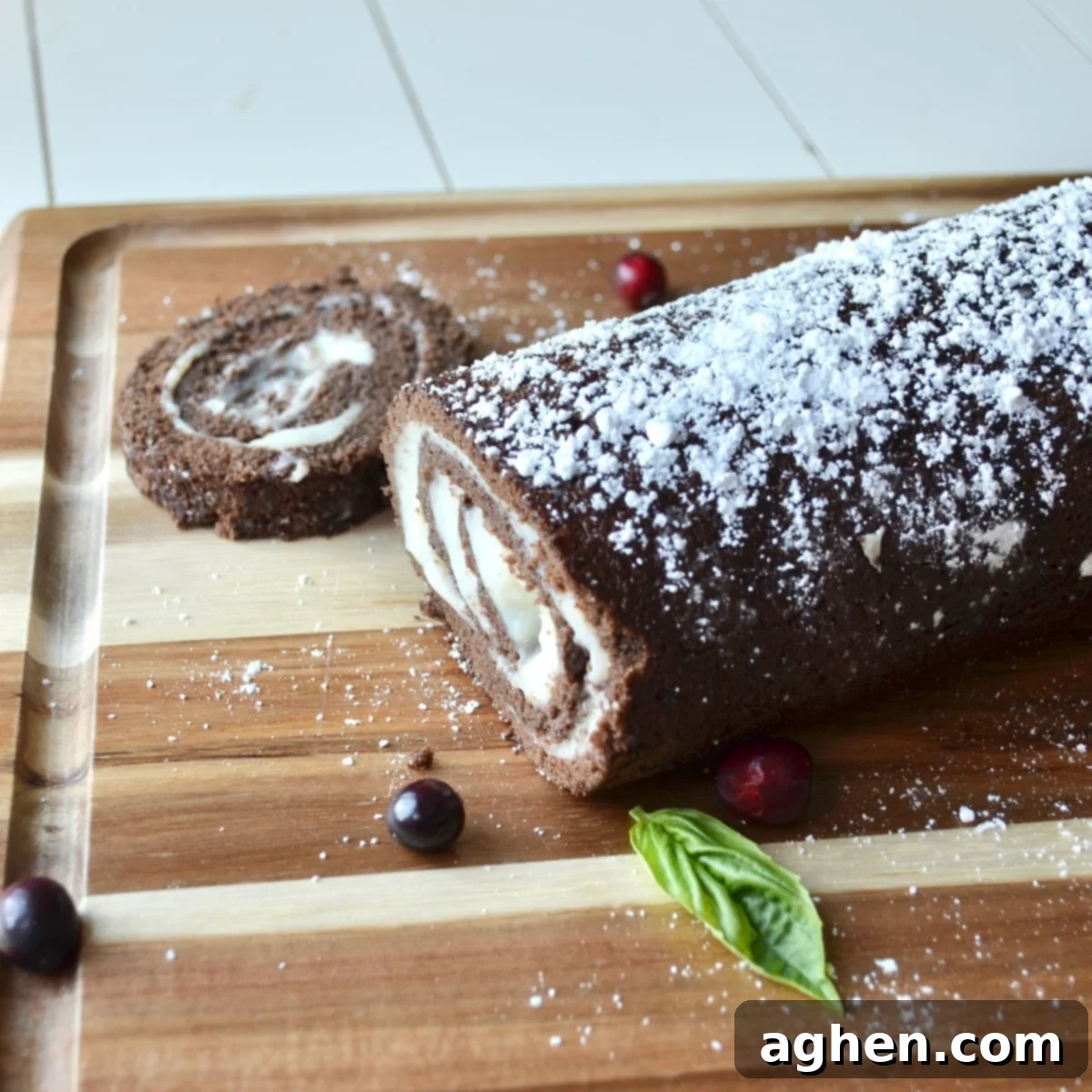 Sliced Weight Watchers Swiss Roll on a cutting board, dusted with powdered sugar