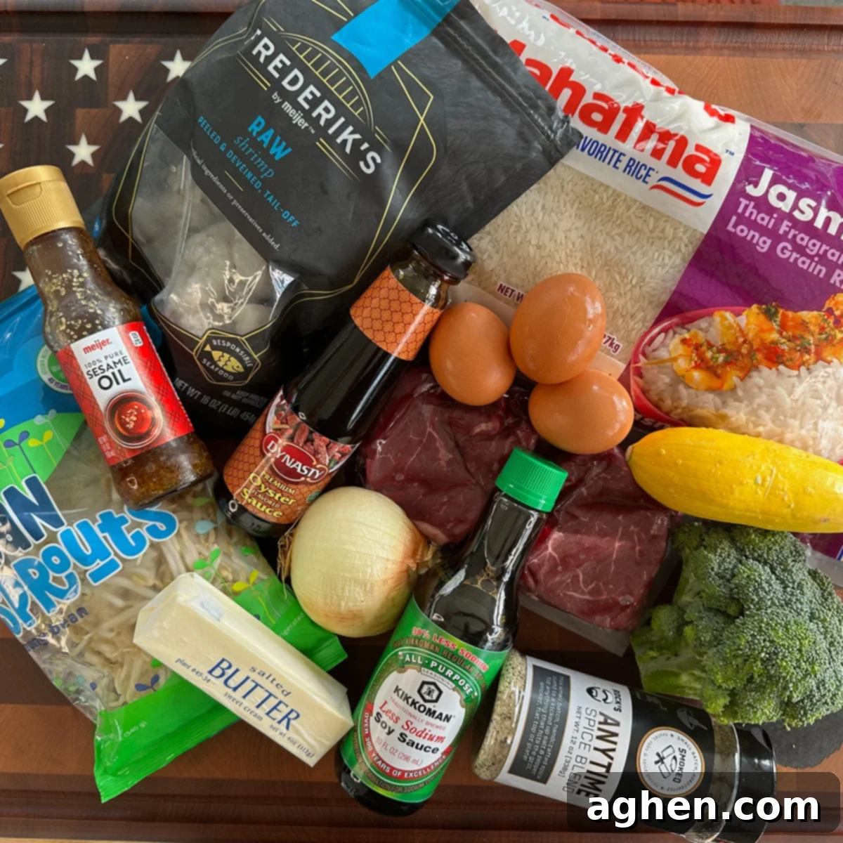 A vibrant selection of fresh ingredients including cooked rice, raw steak, shrimp, eggs, and vegetables laid out for fried rice preparation.
