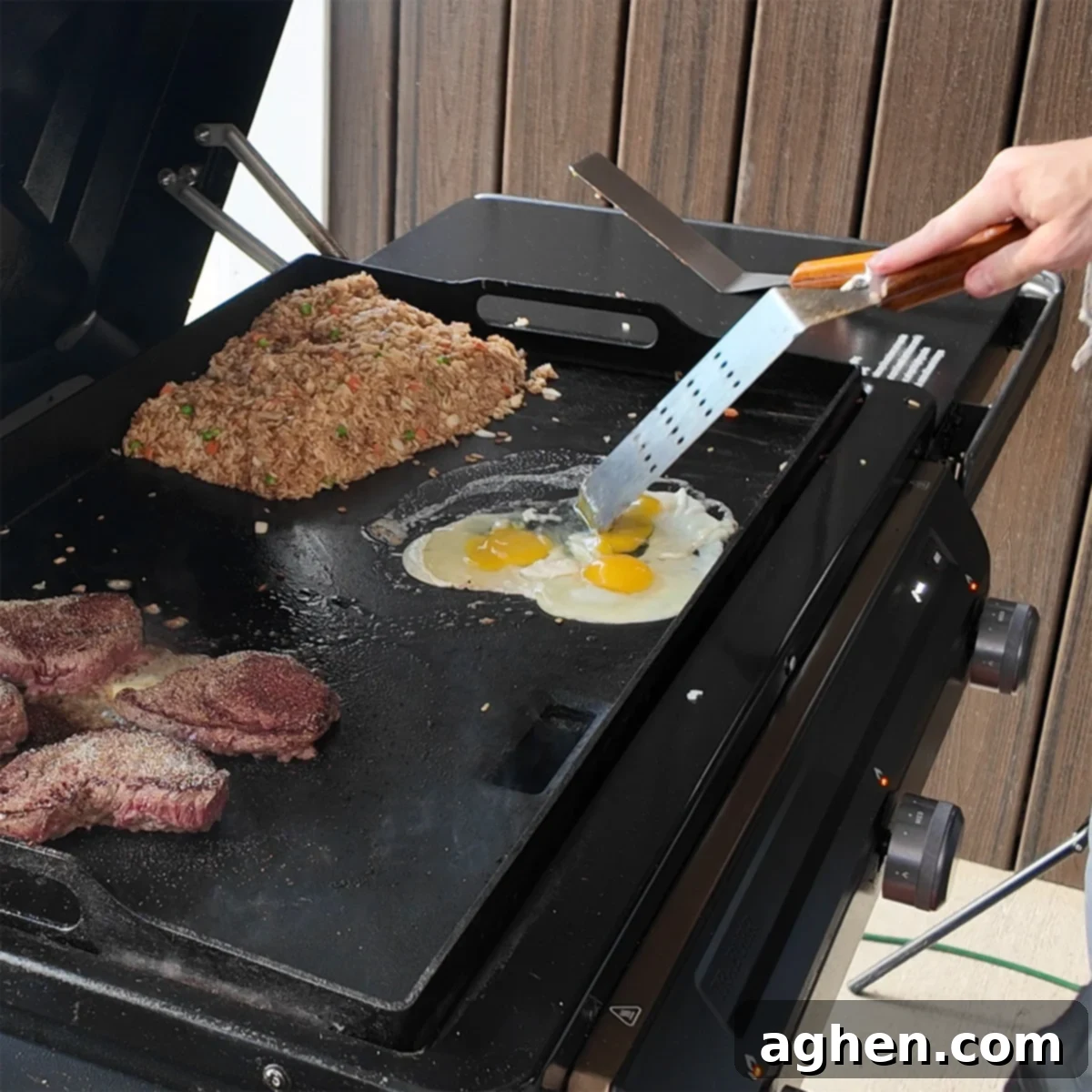 Scrambled eggs cooking on one side of the griddle while fried rice cooks on the other.