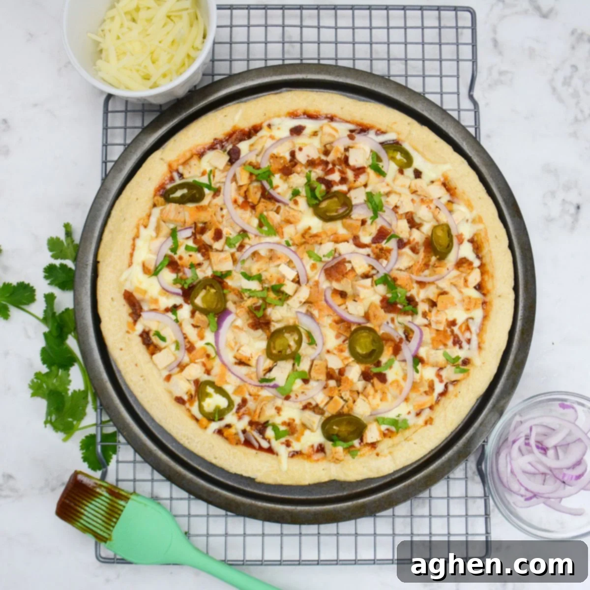 The Blackstone Guide to a Merry Christmas 9 Recipes 10 The cooked pizza is on a cooling rack and surrounded by small bowls with onions and cheese. Additional cilantro is placed to the side and a pastry brush with barbecue sauce is placed to the side.