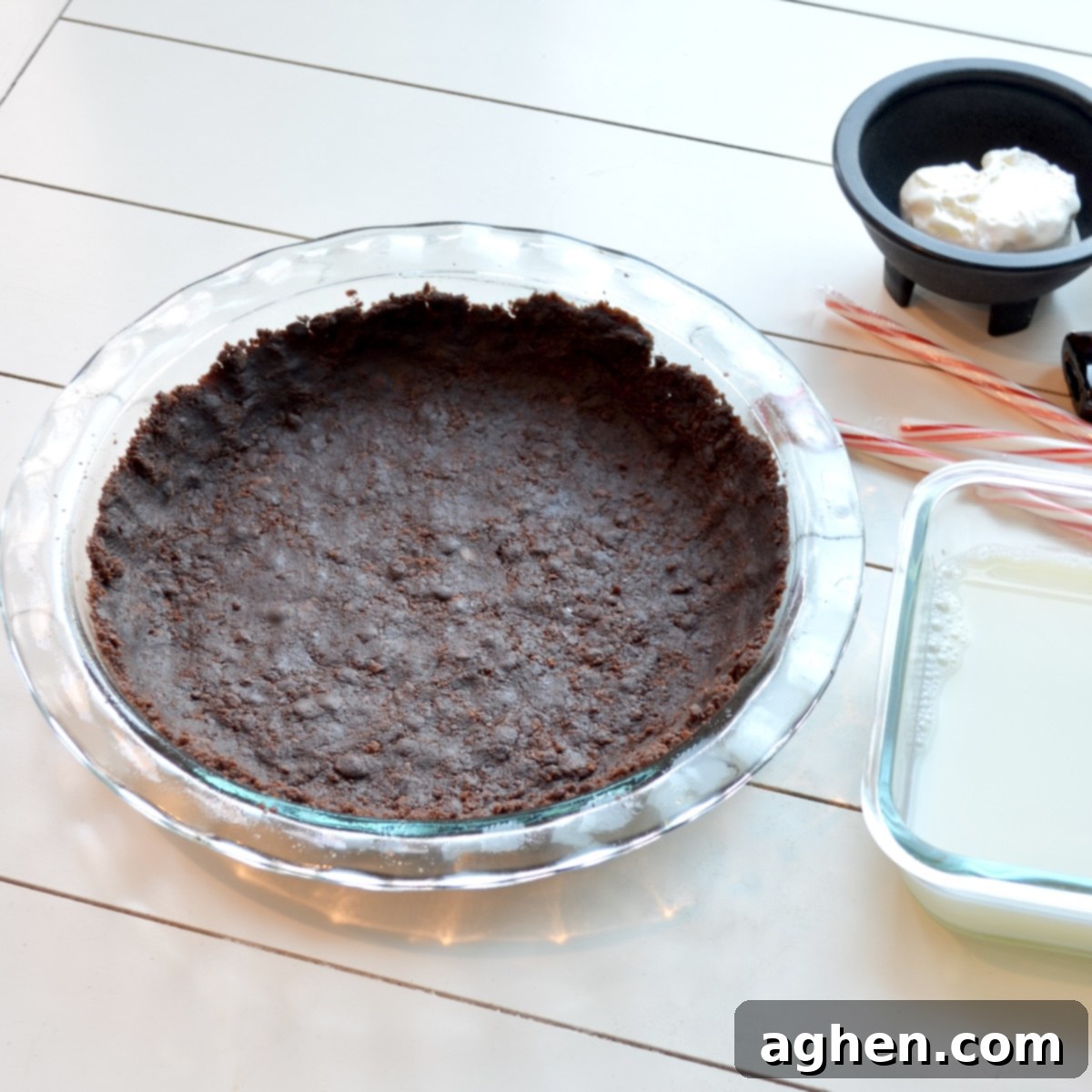 A baked chocolate cookie pie crust in a pie dish, showing its even texture, ready for filling.