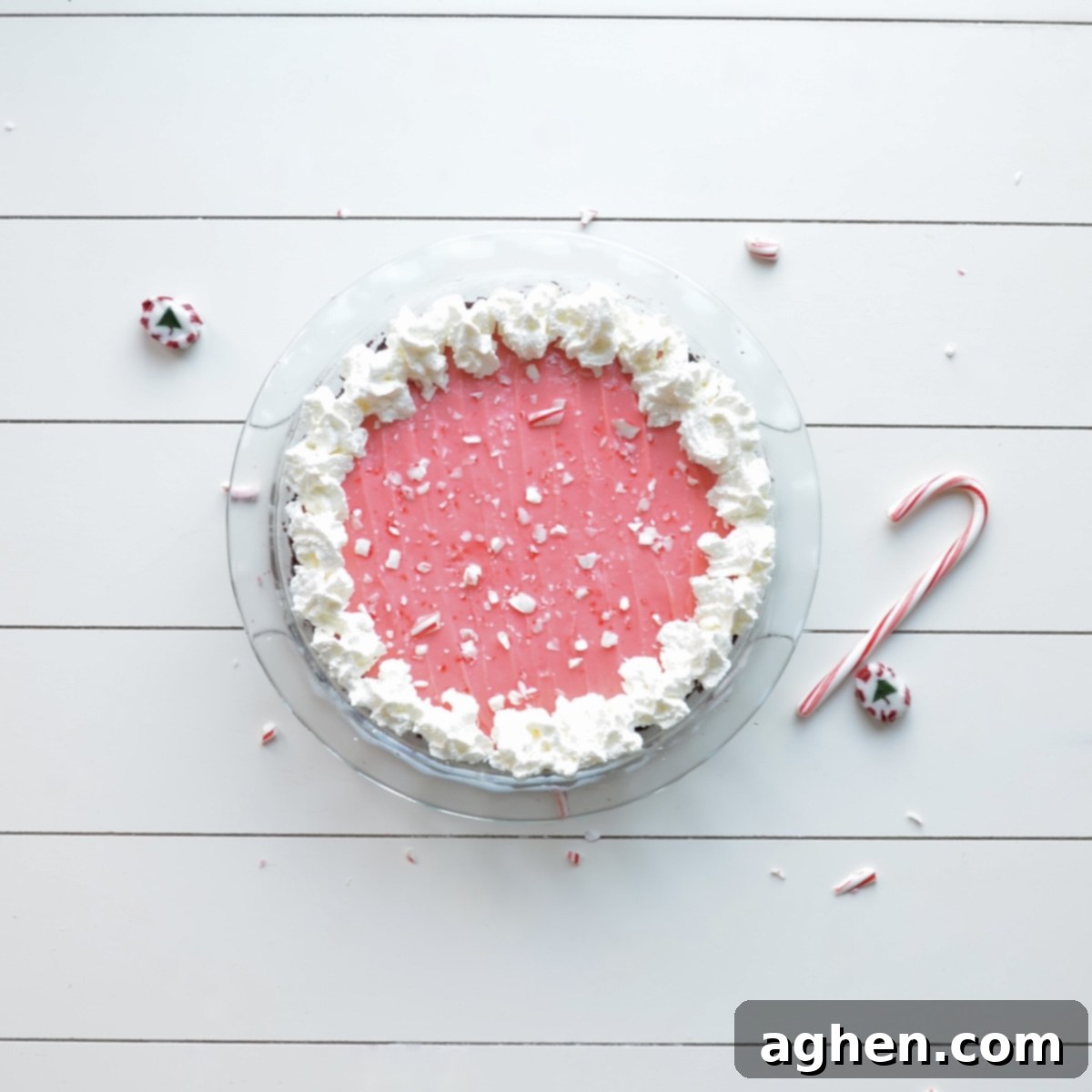 A beautifully decorated peppermint pie, topped with whipped cream and candy canes, ready to be served.