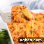 Cheesy sloppy joe casserole with a spatula lifting up a single serving.