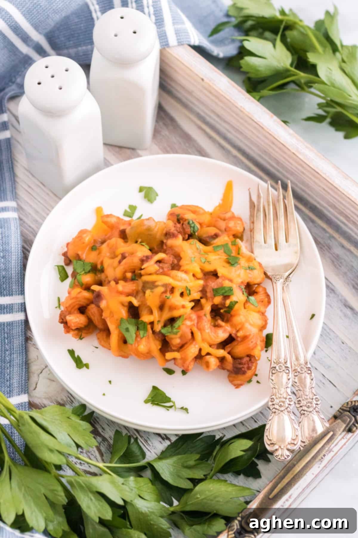 A single serving of Sloppy Joe Pasta Bake on a white plate, garnished with fresh parsley.