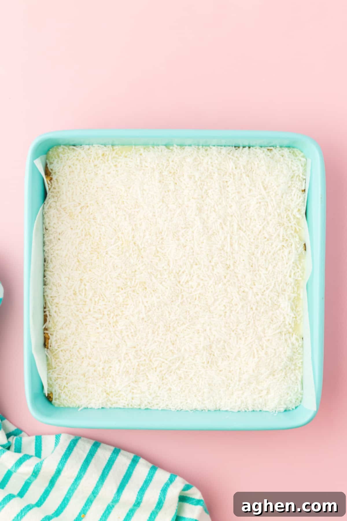 Magical Easter Cookie Bars 6 Shredded coconut in an even layer in square baking pan.