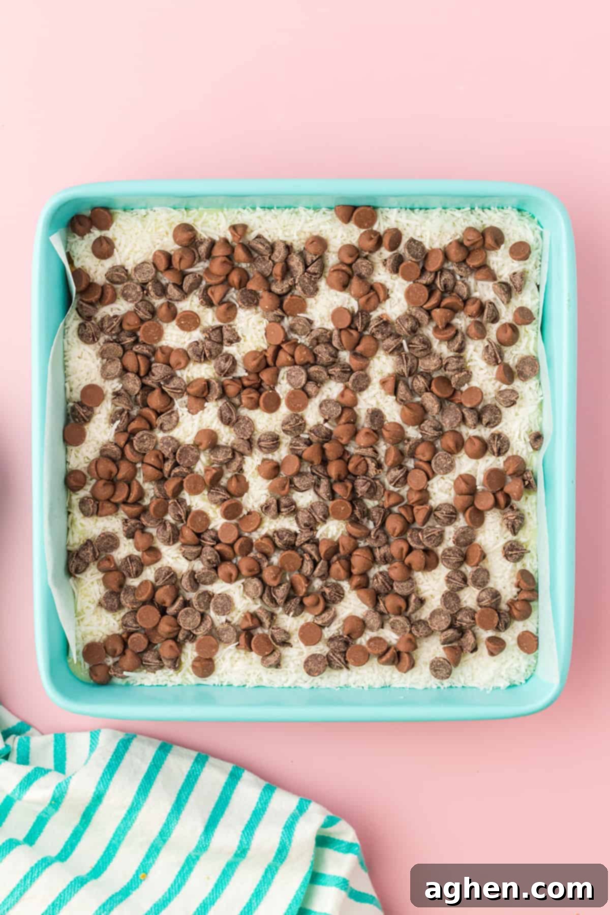Magical Easter Cookie Bars 7 Square casserole dish with shredded coconut topped with chocolate chips.
