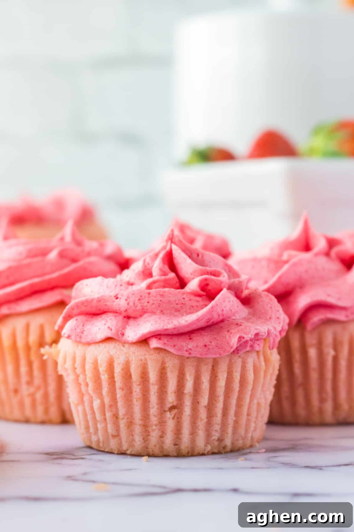 Pink strawberry cupcakes with frosting.
