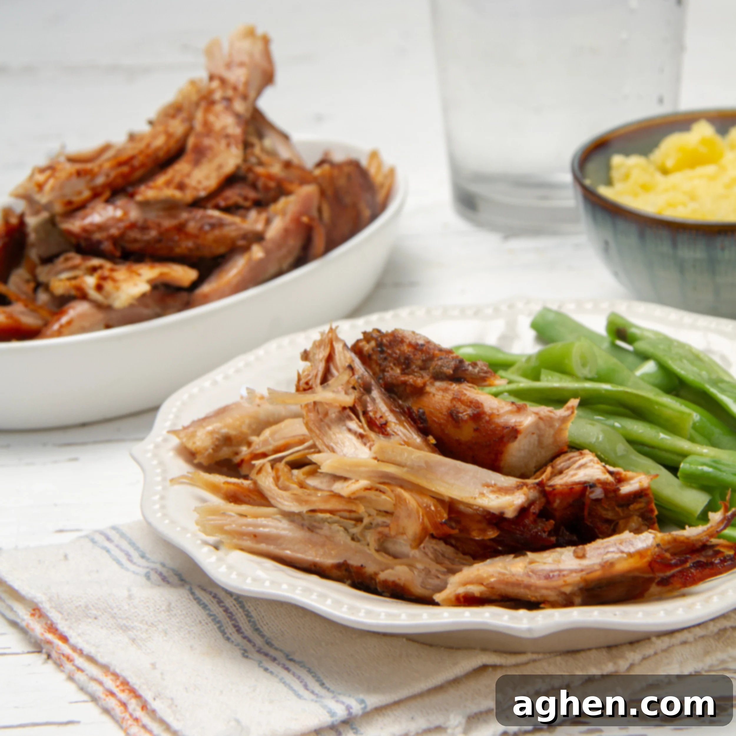 Effortless & Juicy Slow Cooker Turkey Breast 2 Juicy slow cooker turkey breast shredded on a plate with green beans.