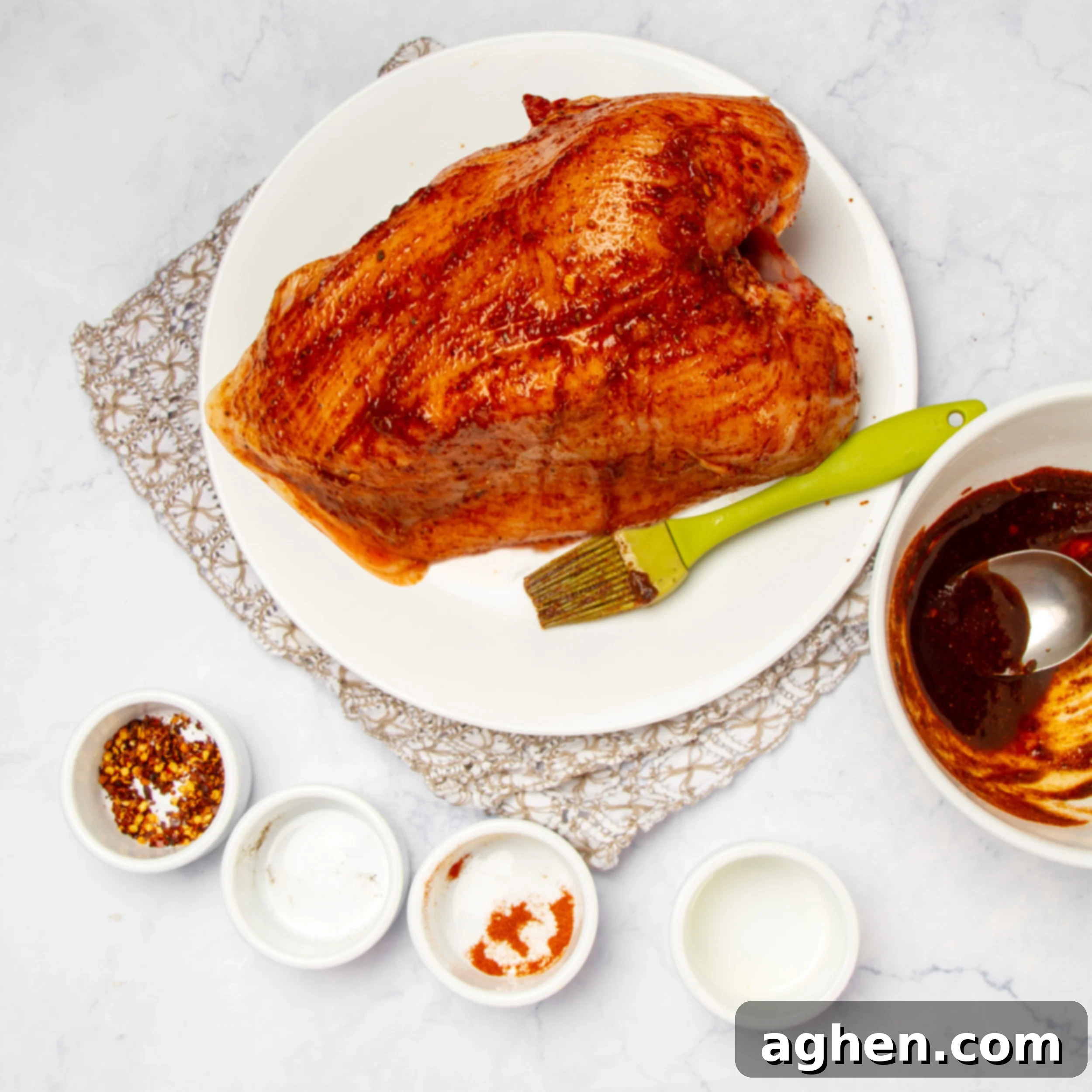 Effortless & Juicy Slow Cooker Turkey Breast 5 Marinade brushed onto the uncooked turkey breast on a plate.