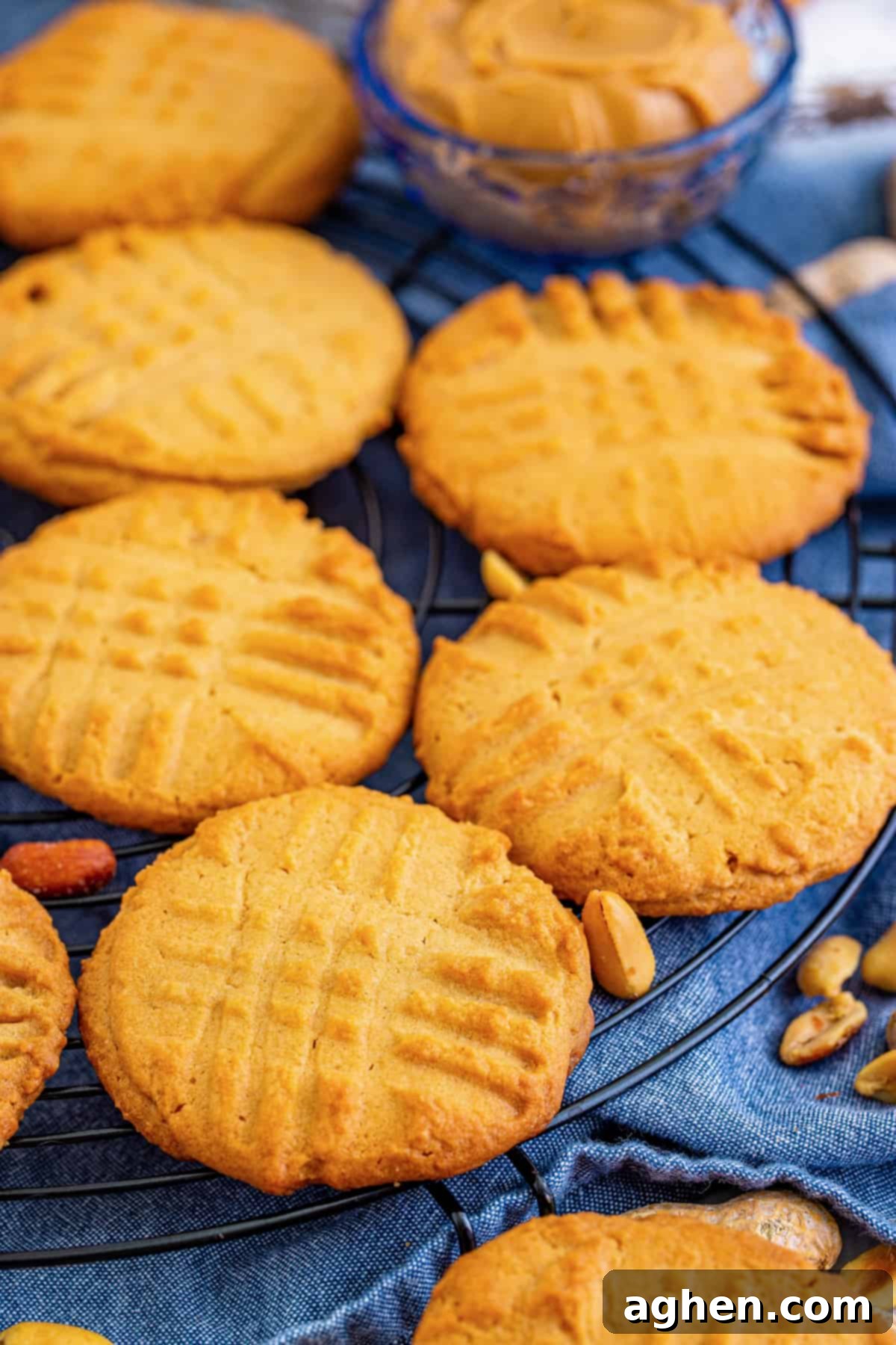 Freshly baked homemade peanut butter cookies with traditional fork marks cooling on a wire rack.