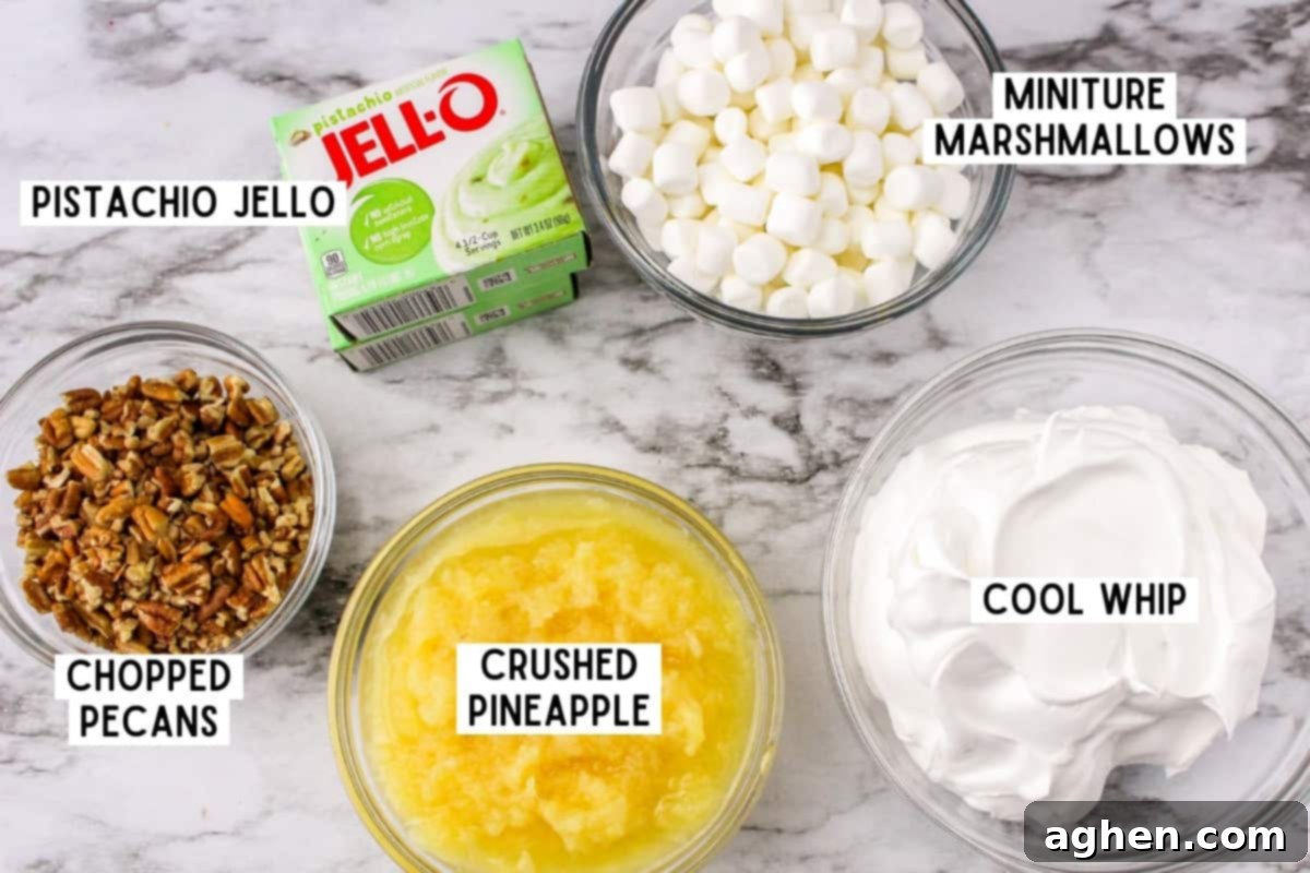 Individual ingredients for Watergate Salad laid out on a white surface, including pistachio pudding mix, canned pineapple, marshmallows, and pecans.