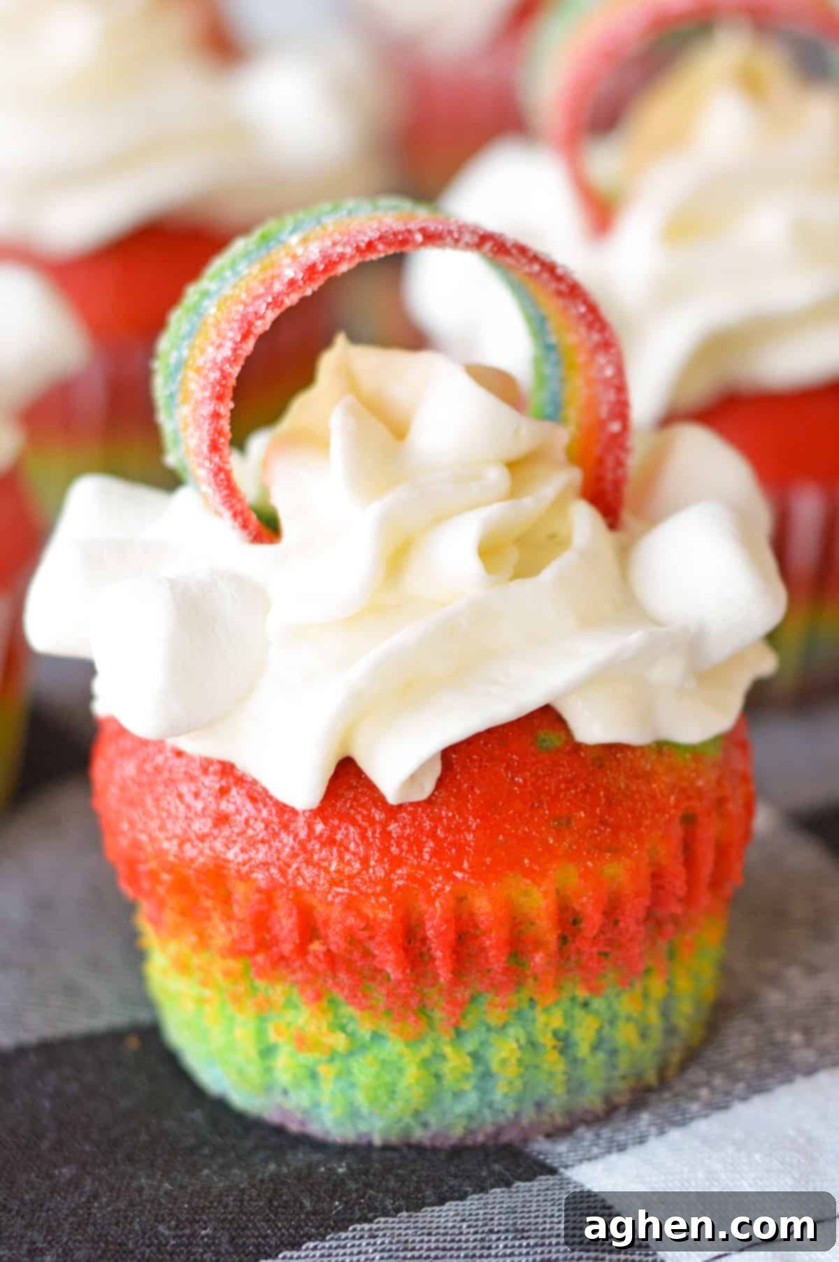 Rainbow Cupcakes with whipped cream cream cheese frosting and decorated with rainbow candy on top.