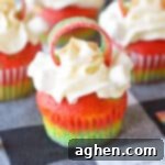 Rainbow Cupcakes with whipped cream cream cheese frosting and decorated with rainbow candy on top.