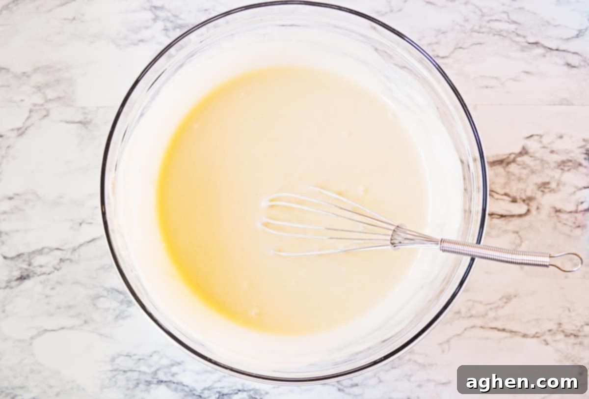 Cupcake batter in mixing bowl with whisk.