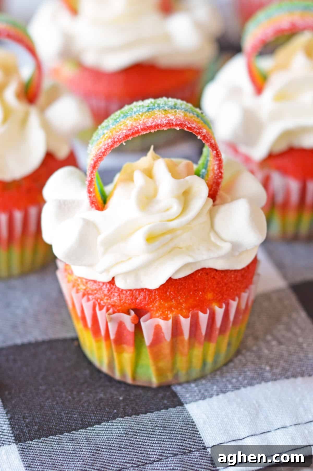 Cute Rainbow Cupcake with vanilla frosting piped on and rainbow airhead candy making an arch across the top.