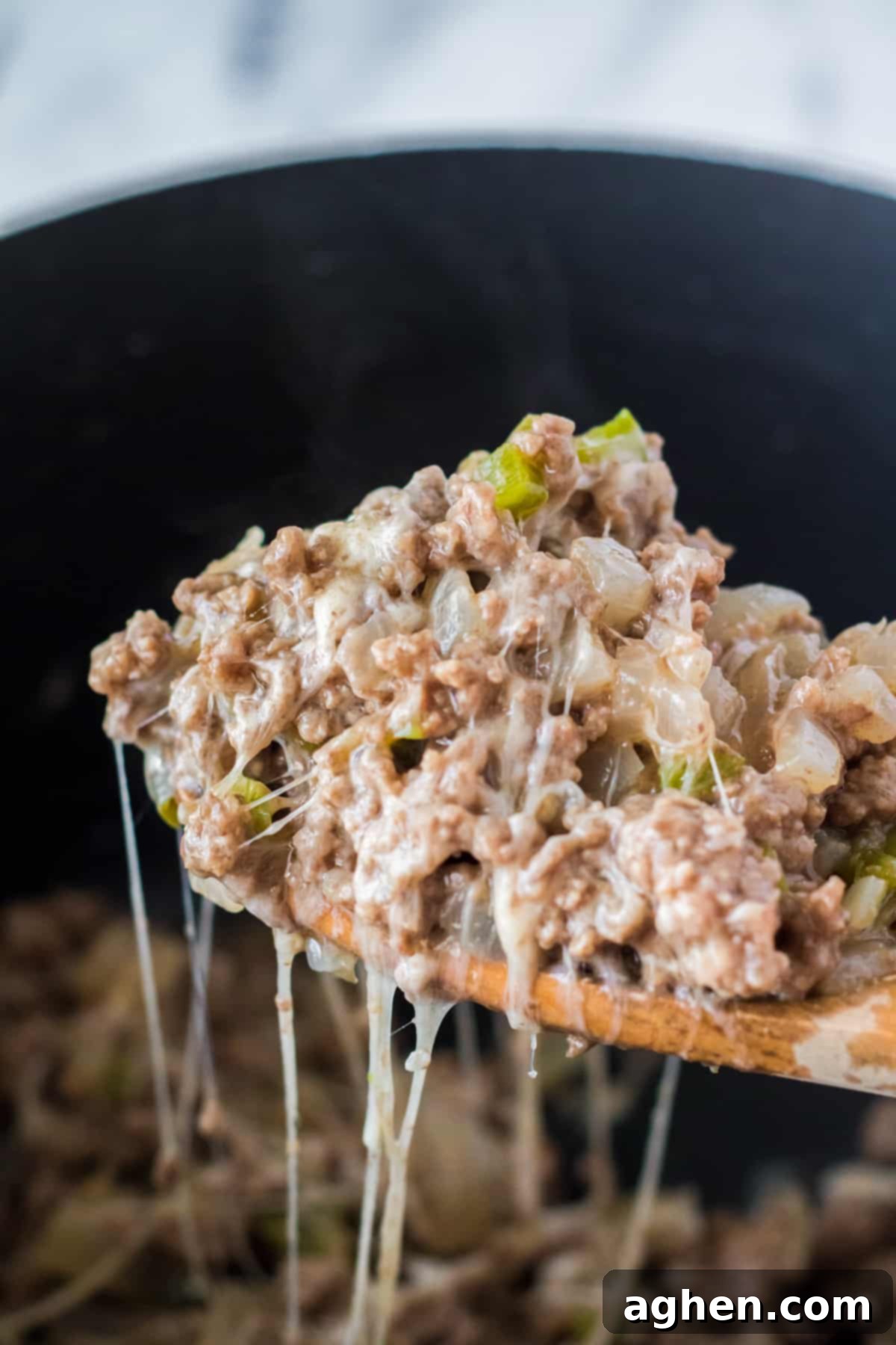 Spoonful of cheesy sloppy joes in slow cooker.